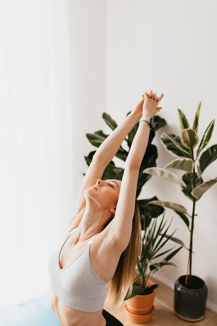 Woman practicing a gentle yoga stretch in a beautifully lit, peaceful home environment.